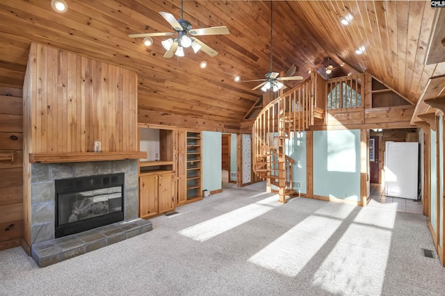 unfurnished living room with visible vents, wood ceiling, a fireplace, and stairway