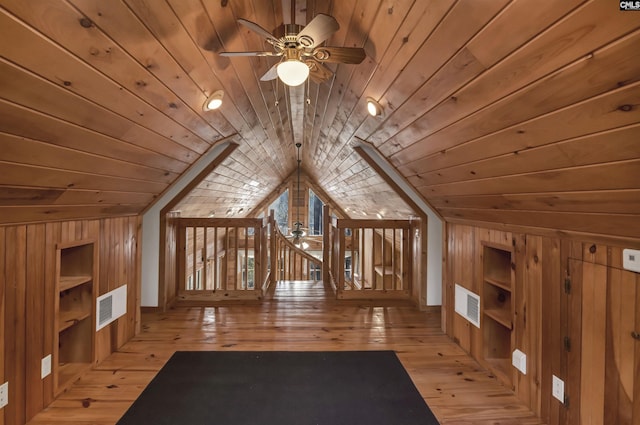 bonus room with visible vents, wood walls, built in shelves, and wood ceiling