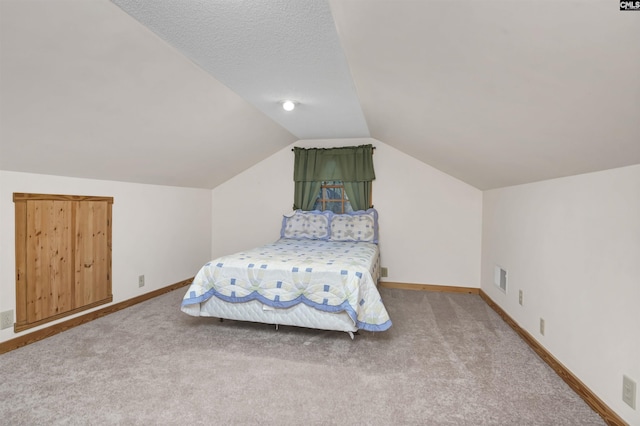 bedroom with lofted ceiling, visible vents, baseboards, and carpet floors