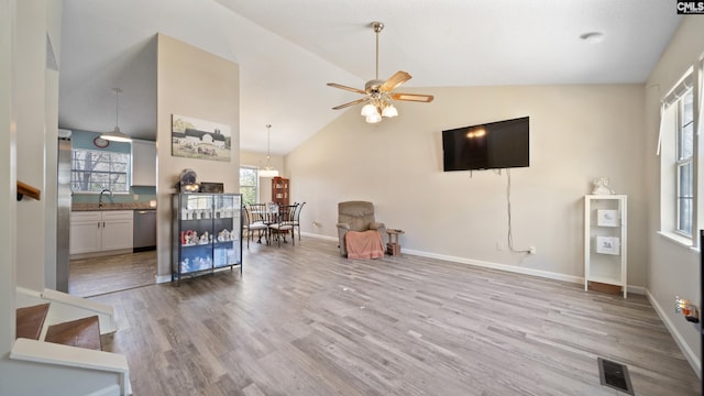 living room featuring visible vents, high vaulted ceiling, a ceiling fan, wood finished floors, and baseboards