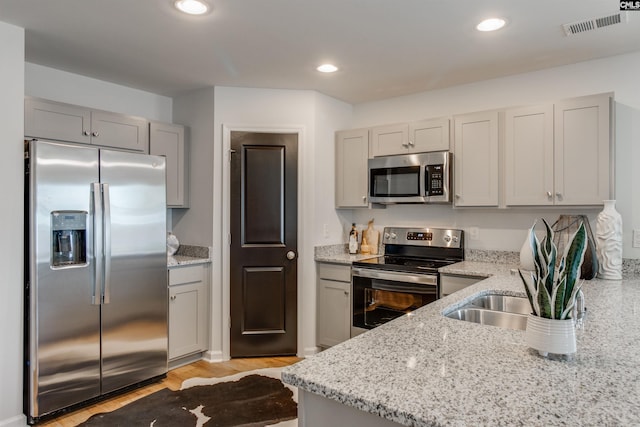 kitchen featuring light stone counters, stainless steel appliances, visible vents, and recessed lighting