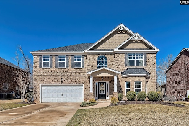 craftsman-style home featuring central air condition unit, an attached garage, brick siding, and driveway