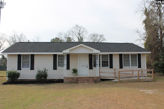 ranch-style house featuring a front yard and roof with shingles