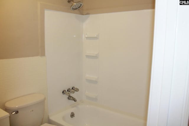 full bathroom with toilet, tile walls, and bathing tub / shower combination