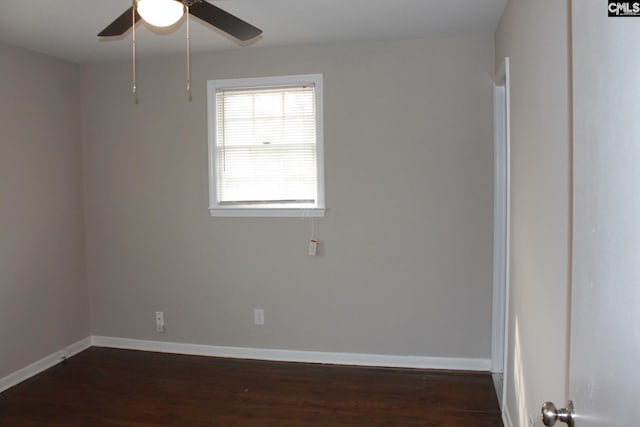 spare room with dark wood finished floors, baseboards, and ceiling fan