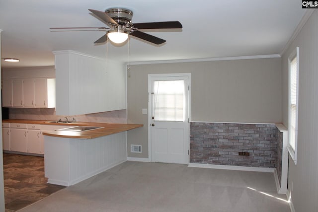 kitchen featuring a wealth of natural light, visible vents, ornamental molding, and white cabinets