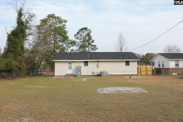 back of house featuring cooling unit, a lawn, and fence