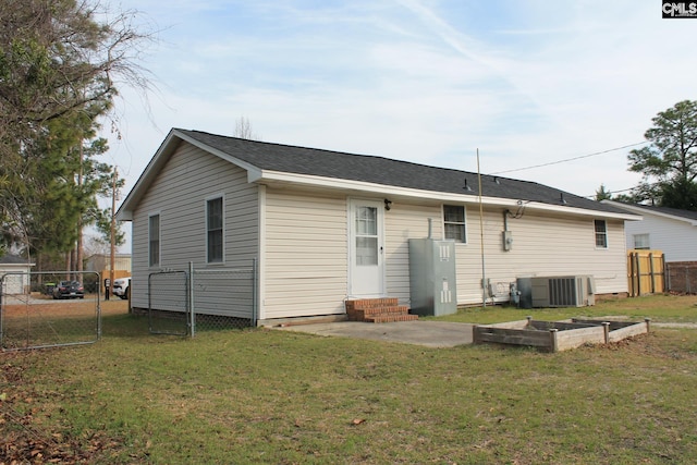 back of house featuring fence, entry steps, central AC, a lawn, and a gate