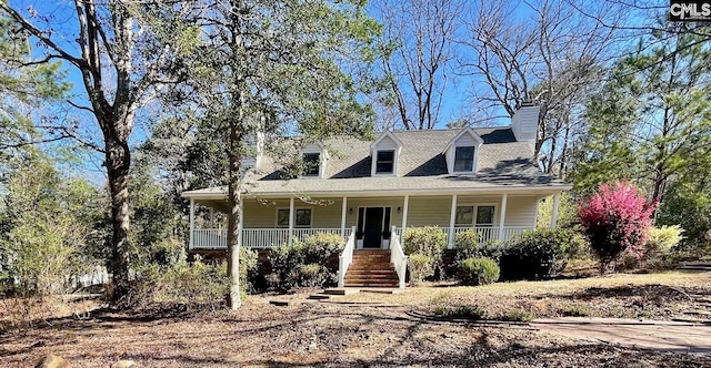 cape cod-style house with a porch and a chimney