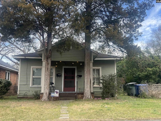 bungalow-style house featuring a porch and a front lawn