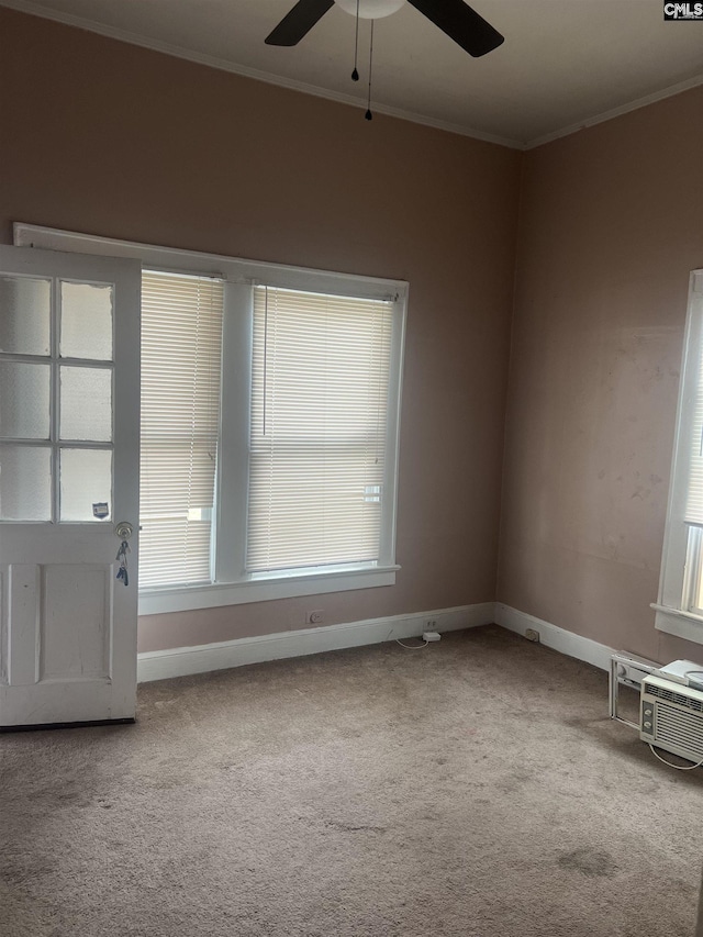 carpeted empty room with a ceiling fan, crown molding, baseboards, and a wall unit AC