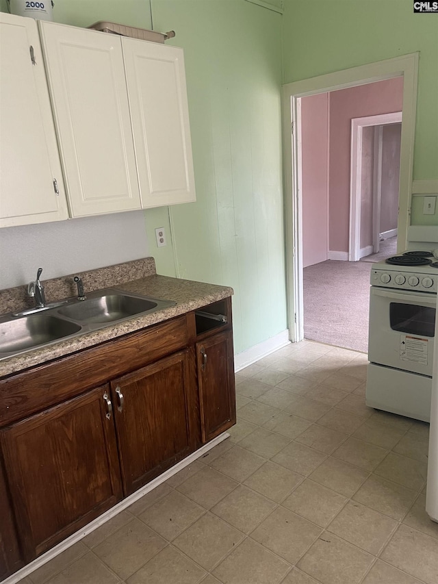 kitchen featuring a sink, dark brown cabinets, white electric range oven, and white cabinetry