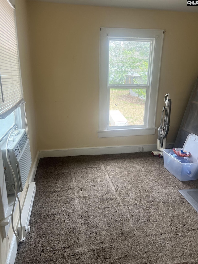 carpeted spare room featuring cooling unit and baseboards