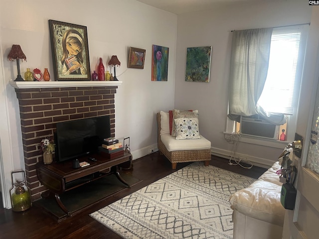 living area featuring cooling unit, wood finished floors, and baseboards