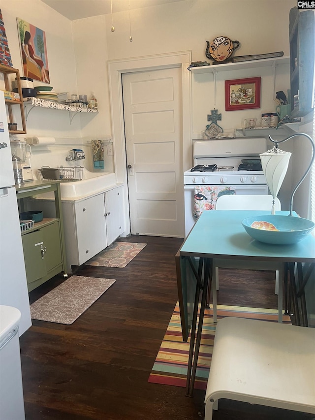 kitchen featuring a sink, white range with gas cooktop, and dark wood finished floors