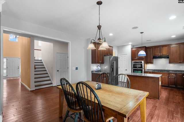 dining room featuring recessed lighting, dark wood-type flooring, and stairs