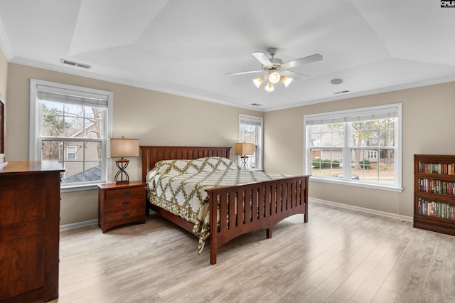 bedroom with visible vents, baseboards, wood finished floors, and ornamental molding