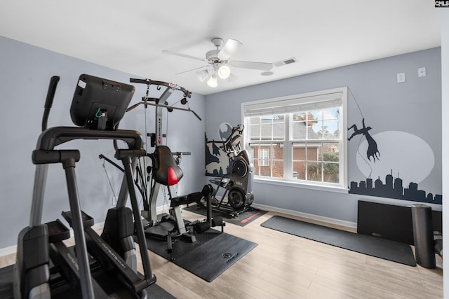 exercise room featuring ceiling fan, visible vents, baseboards, and wood finished floors