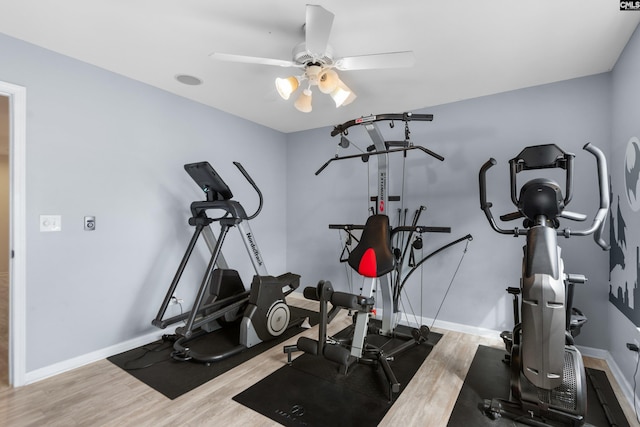 exercise area featuring a ceiling fan, wood finished floors, and baseboards