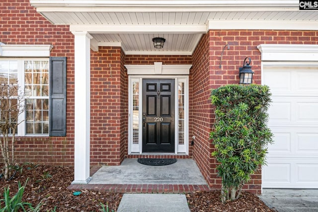 property entrance featuring brick siding and a garage