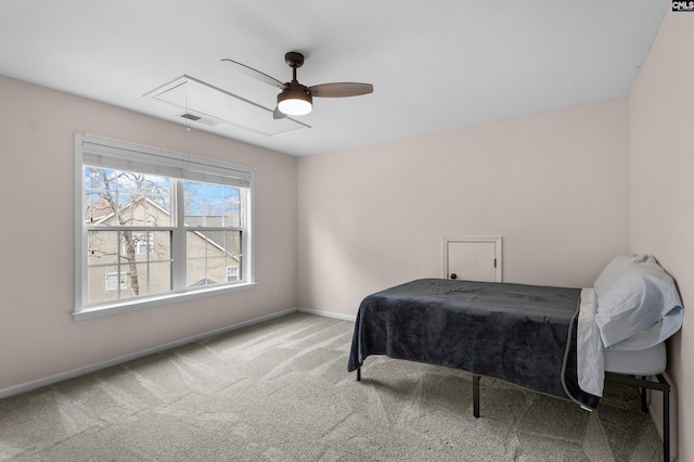 carpeted bedroom featuring visible vents, baseboards, attic access, and ceiling fan