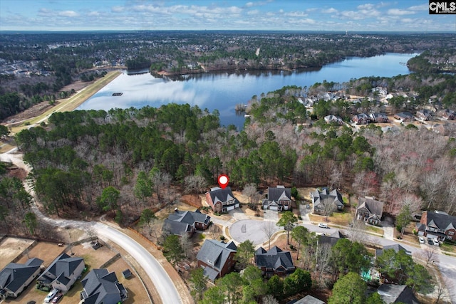 birds eye view of property with a wooded view, a water view, and a residential view