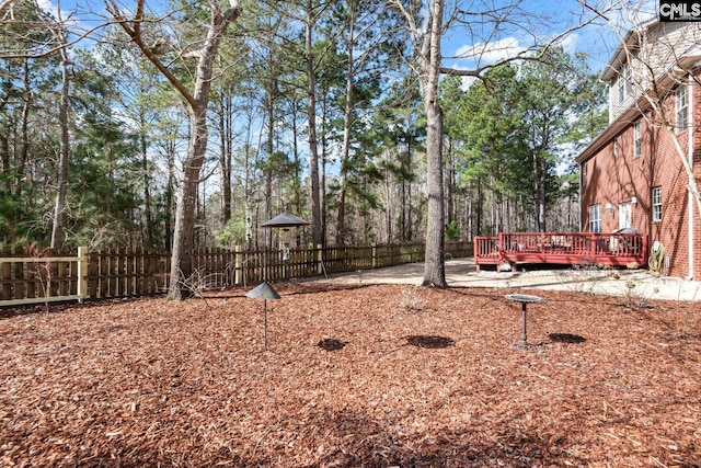 view of yard featuring a wooden deck and fence