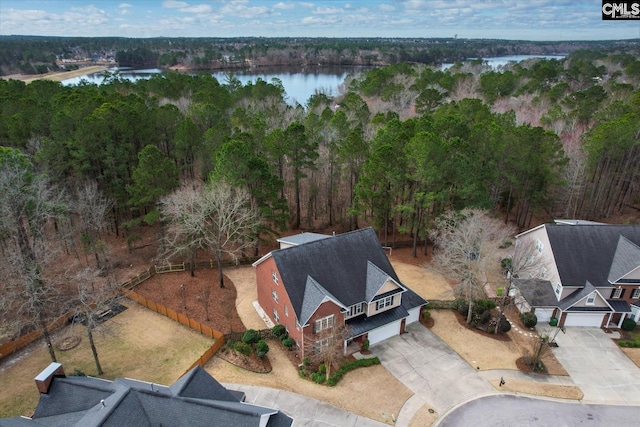 aerial view featuring a wooded view and a water view