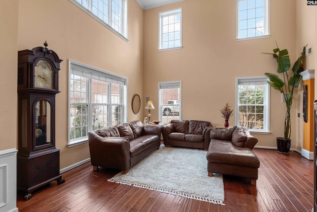 living room with a wealth of natural light and dark wood-type flooring