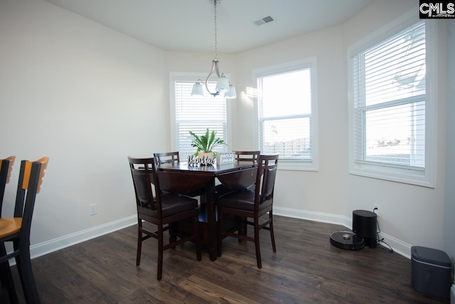 dining area with dark wood-style floors, visible vents, an inviting chandelier, and baseboards