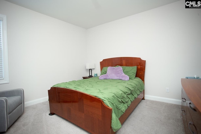 bedroom with light colored carpet and baseboards