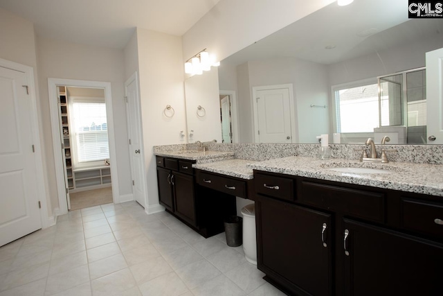 bathroom with vanity, a shower stall, baseboards, and tile patterned flooring