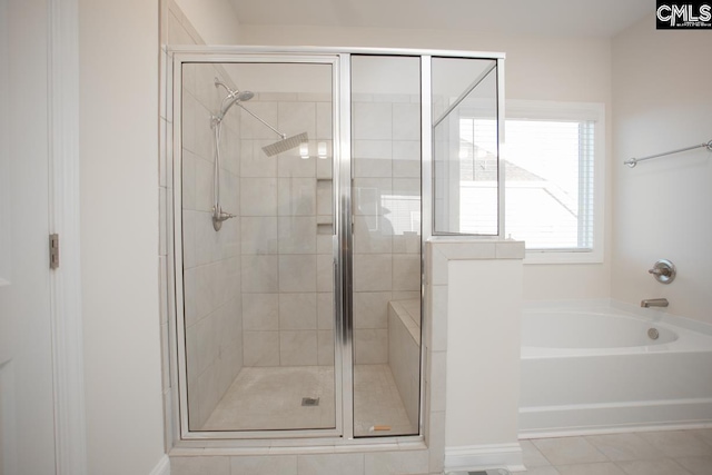 bathroom with a bath, a shower stall, and tile patterned floors