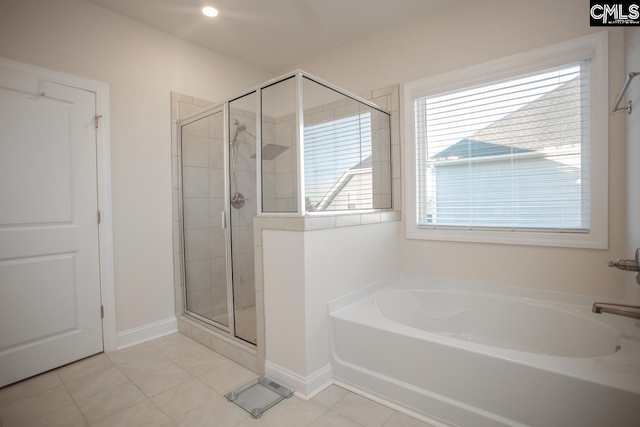 bathroom with a bath, tile patterned flooring, a shower stall, and baseboards