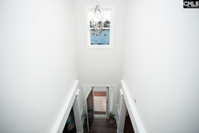 staircase featuring a notable chandelier and wood finished floors