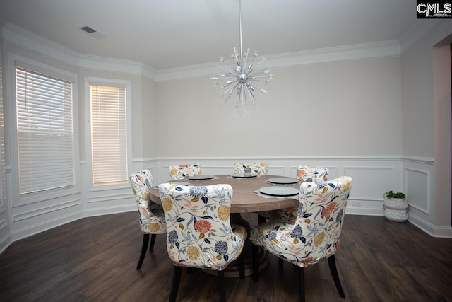 dining space with dark wood finished floors, a chandelier, wainscoting, and crown molding