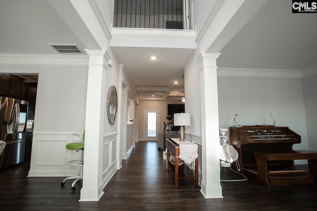 entrance foyer featuring dark wood finished floors, visible vents, ornate columns, and ornamental molding