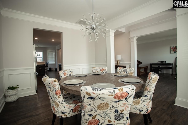 dining space with dark wood finished floors, an inviting chandelier, decorative columns, and ornamental molding