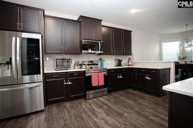 kitchen featuring a peninsula, dark wood-style flooring, stainless steel appliances, decorative backsplash, and light countertops