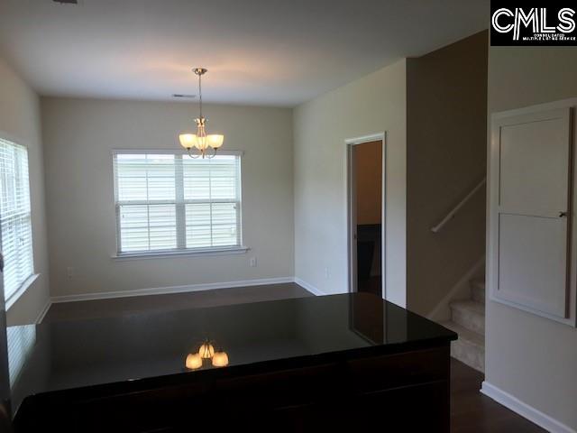 kitchen featuring a wealth of natural light, a chandelier, dark countertops, and hanging light fixtures