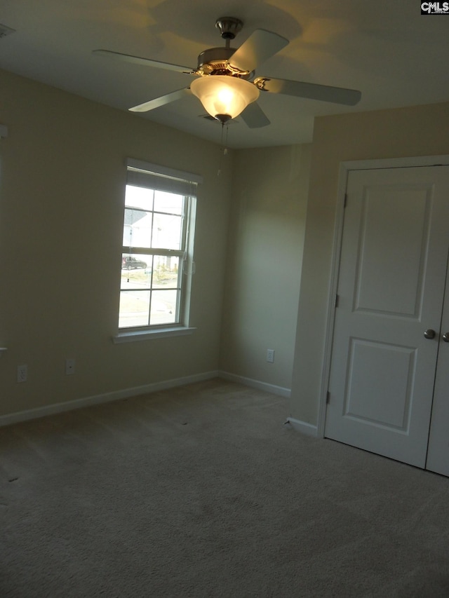 unfurnished room featuring baseboards, carpet, and a ceiling fan