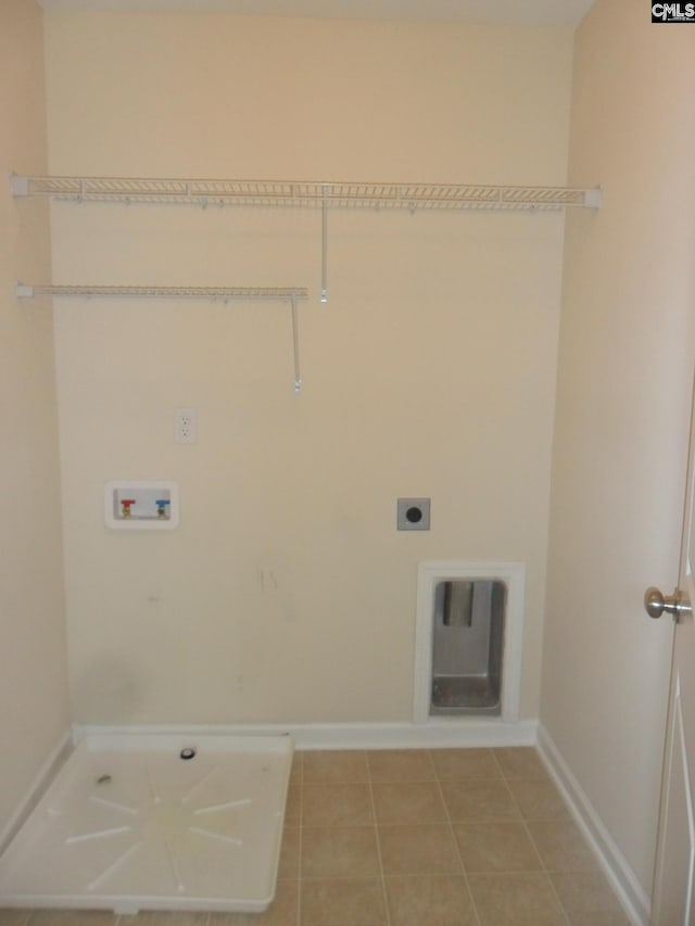 clothes washing area with electric dryer hookup, light tile patterned floors, baseboards, hookup for a washing machine, and laundry area