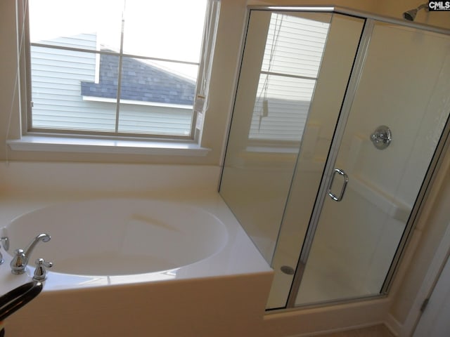 full bath featuring a stall shower and a garden tub