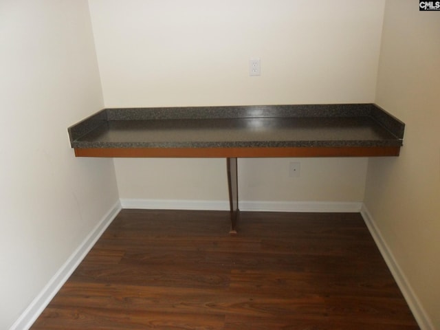 room details featuring built in desk, baseboards, and wood finished floors