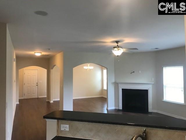 unfurnished living room featuring baseboards, arched walkways, and a fireplace