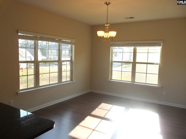 unfurnished dining area featuring a notable chandelier, a healthy amount of sunlight, visible vents, and baseboards