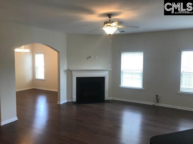 unfurnished living room featuring a wealth of natural light, a fireplace with flush hearth, and dark wood-style flooring