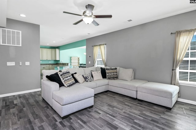 living area featuring dark wood-type flooring, baseboards, and visible vents