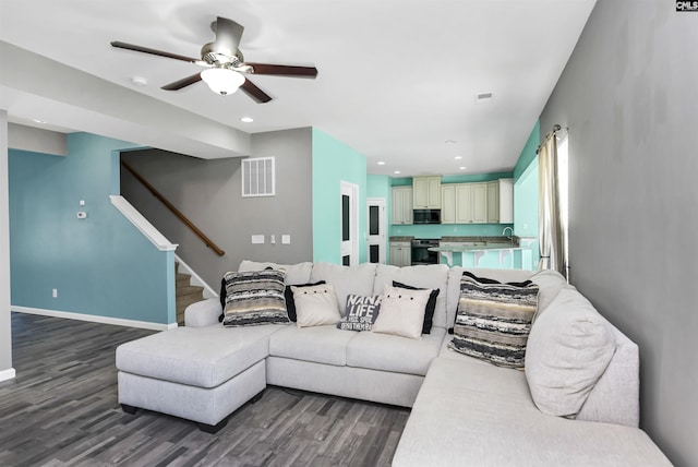 living room featuring visible vents, stairs, baseboards, and wood finished floors