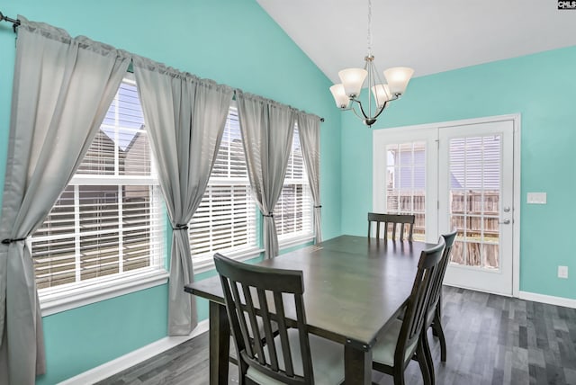 dining space with a chandelier, baseboards, lofted ceiling, and wood finished floors